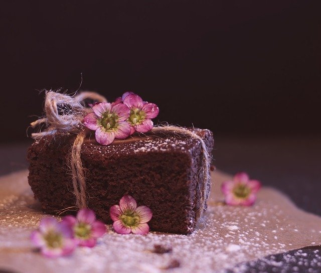 Schokoladenkuchen mit Zucker und Blumen